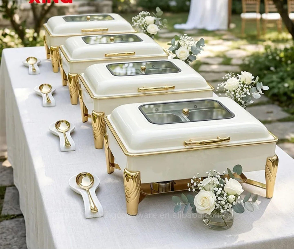 White and Gold Hydraulic Chafing Dishes lined up at outdoor wedding buffet with flowers