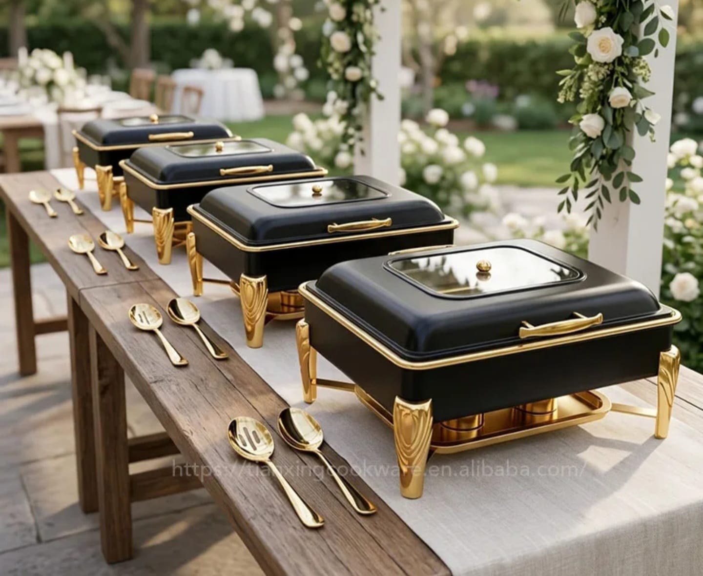 Black and Gold Hydraulic Chafing Dishes lined up at outdoor wedding buffet with gold serving spoons