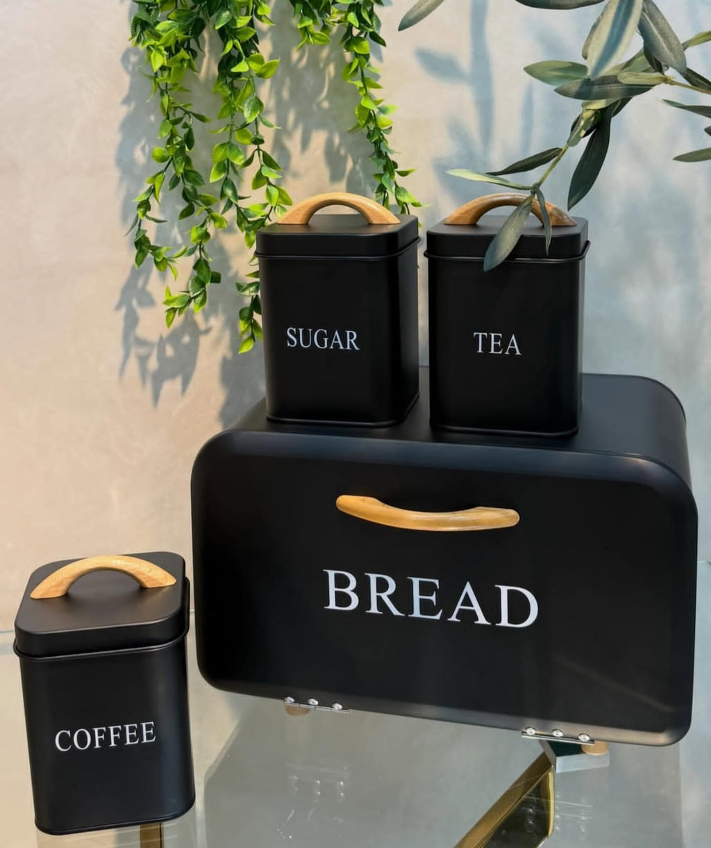 4pc Black Metal Bread Bin and Canister Set with wood handles - lifestyle display with plants