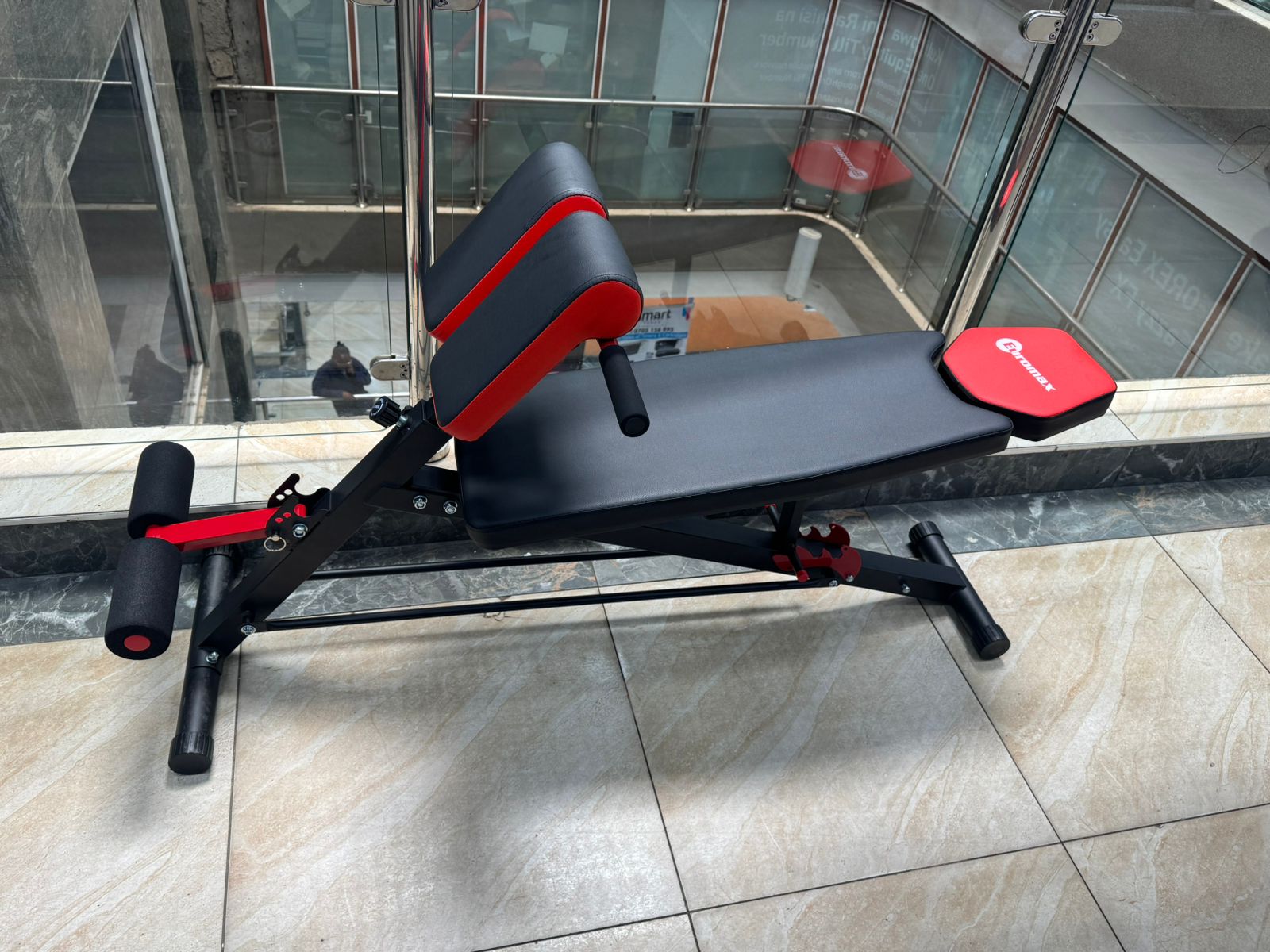 Adjustable decline sit-up bench with foam leg support rollers - black and red