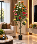 Artificial flowering tree with red, pink, white, orange and yellow blooms and green foliage in a black pot.